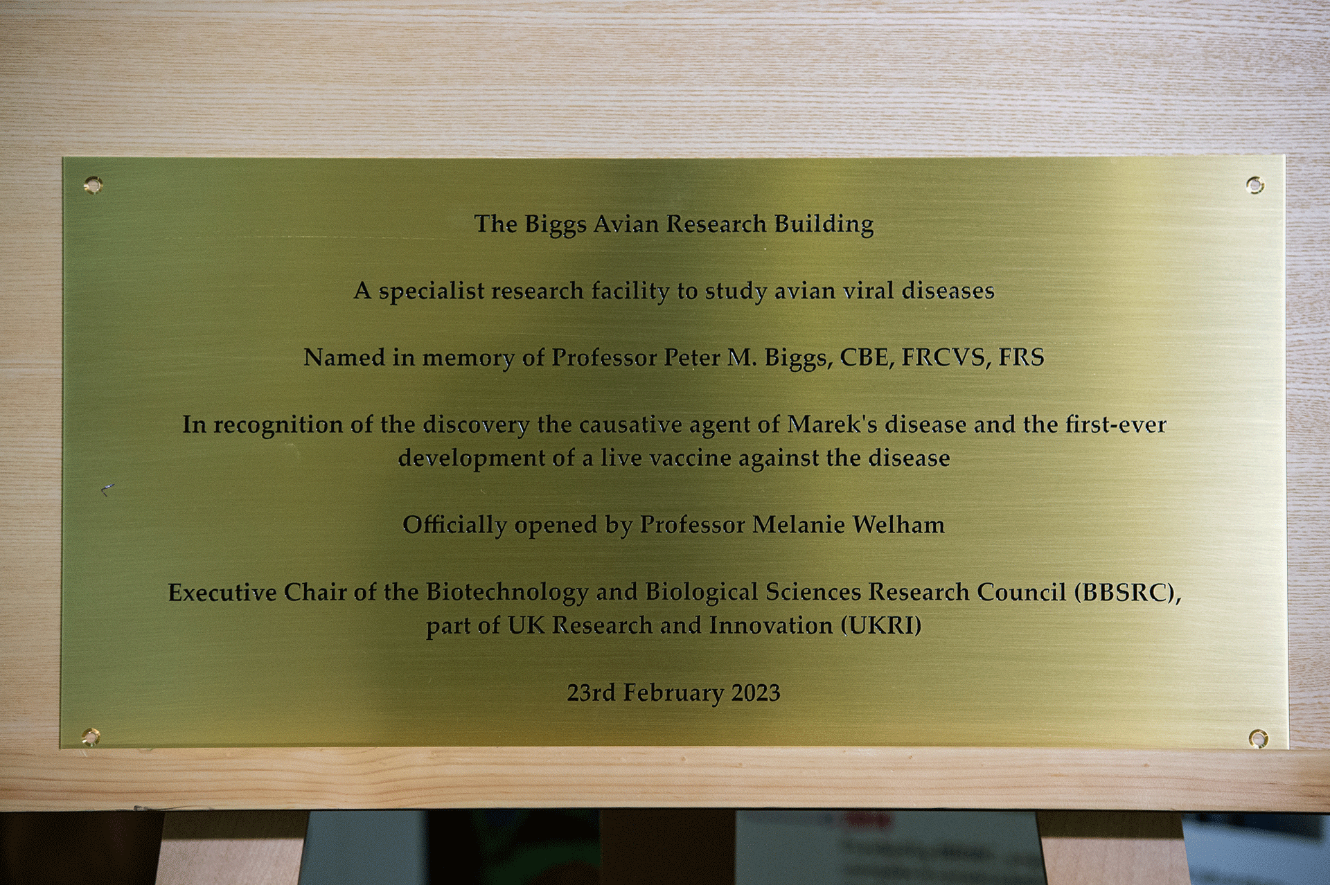 Brass plaque with black text to recognise the work of Professor Peter Biggs and who opened the building